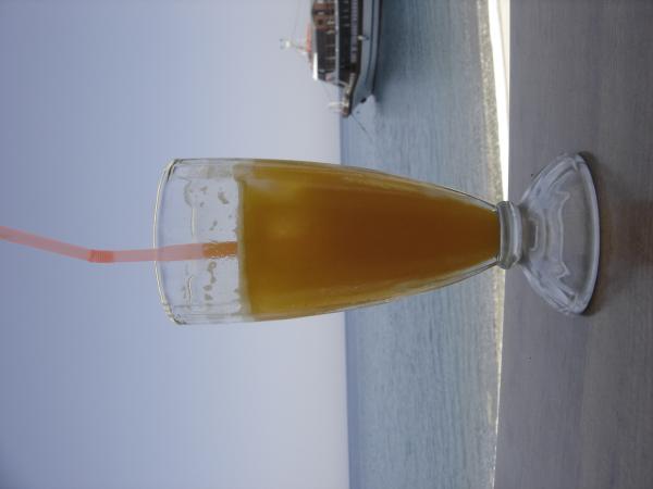 This is orange juice in front of the sea. The boat behind it is the one we came there with. Unfortunately, it is upside down.