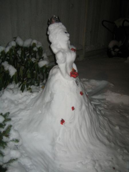I've always loved snow, and building snowmen is great fun, though this one can hardly be called a snowMAN. Instead of the traditional "three snowballs for body, add hands, a hat, a scarf and a carrot for nose" kind of snowman I decided to make a Snow Princess instead. The flowers are made of a red napkin and the crown is made of a piece of silver paper, but other than that (okay, there are stones for eyes and a twig as a mouth) it's pure snow :)