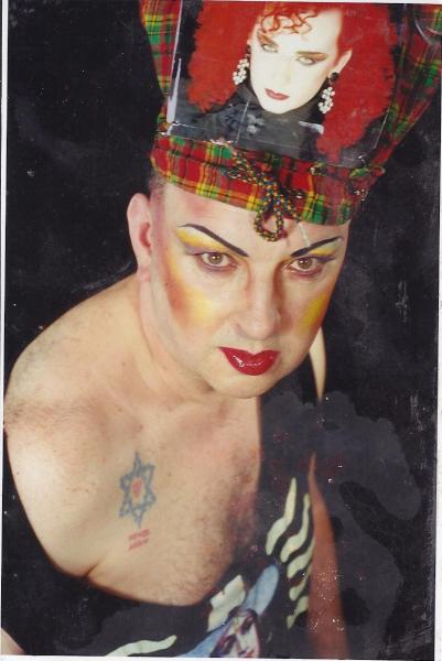 my tattoo is a Star of David formed of barbed wire with a pink triangle in its center, below it reads "Never Again."